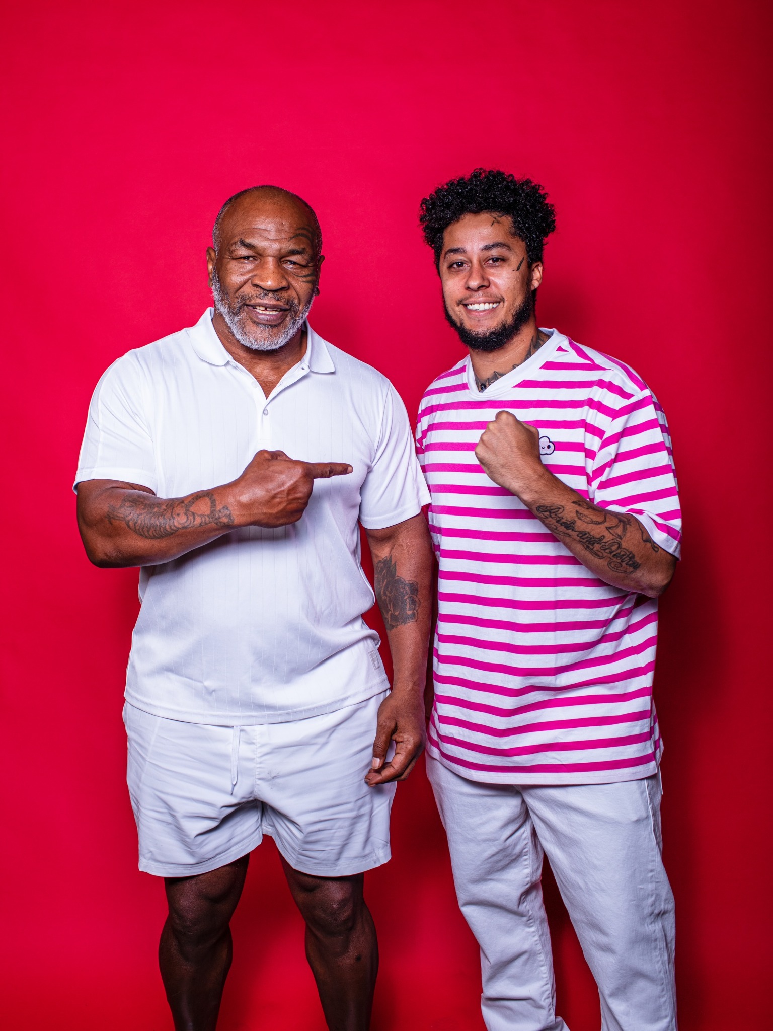 Mike Tyson and Cory Van Lew together in front of a red backdrop